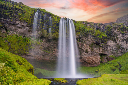 Typical landscape for the summer in Iceland. At the foot of the waterfall Seljalandsfoss crowds of tourists © Pavel