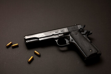 Pistol gun 9mm and ammunition, on black table. Auto metal weapon side view