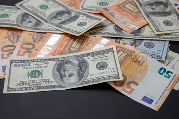 Banknotes. Euro and US dollars notes pile on black background