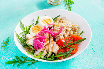 Fresh salad. Breakfast bowl with oatmeal, chicken fillet, tomato, red onion and boiled egg. Healthy food. Vegetarian buddha bowl.