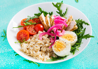 Fresh salad. Breakfast bowl with oatmeal, chicken fillet, tomato, red onion and boiled egg. Healthy food. Vegetarian buddha bowl.