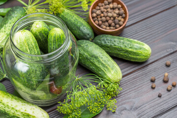 Garlic, cucumbers and cherries in glass jar.