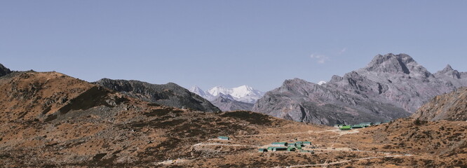 remote mountain village with alpine landscape and snowcapped gori chen peak in the background, arunachal pradesh, north east india