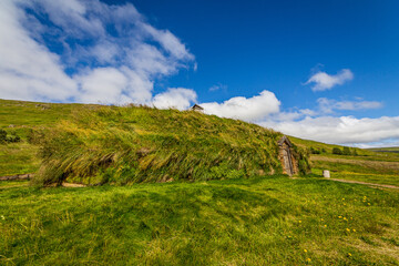 Fototapeta na wymiar Turf houses in Iceland with grass roof under blue sky