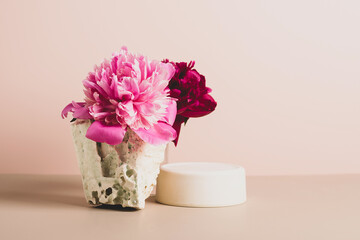Modern podium wooden geometric shapes stone green fresh plant flowers peony pastel pink background. Abstract background