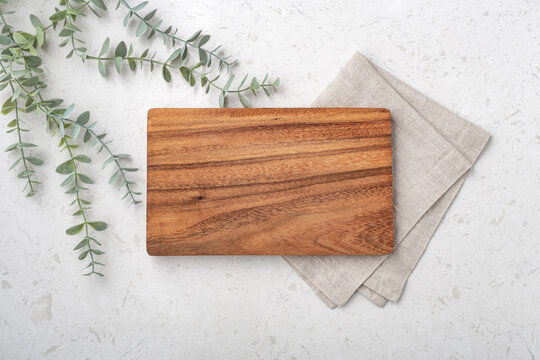 Wood cutting board with linen napkin and plant