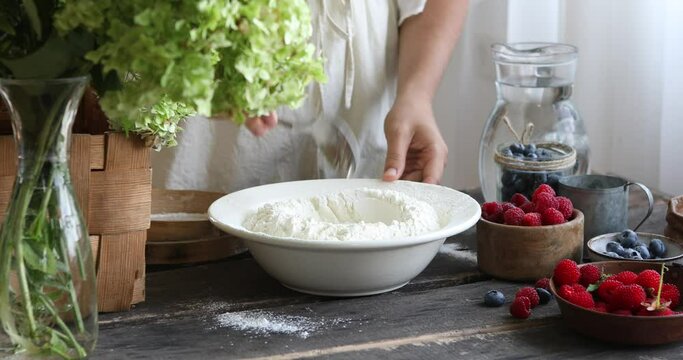 Woman adds sugar, salt, eggs the dough with spatula to make pierogi step-by-step recipe