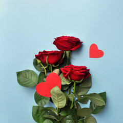 A bouquet of red roses and a heart next to it on a blue background