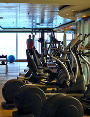 Treadmills and other cardio equipment and weight machines for muscle workout in fitness center gym on modern cruiseship cruise ship liner to stay fit during cruising	