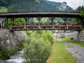 Fototapeta na wymiar Old wooden bridge with flowers in Matrei in Osttirol