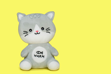 Funny toy cat, gray color, on a yellow background. Educational toys for children.