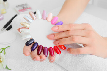 Female client choosing color of nail polish in beauty salon