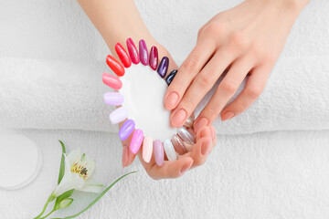 Female client choosing color of nail polish in beauty salon