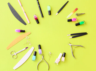 Frame made of professional tools for manicure and nail polishes on color background