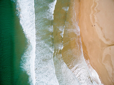 aerial of surf  and people on sandy beach