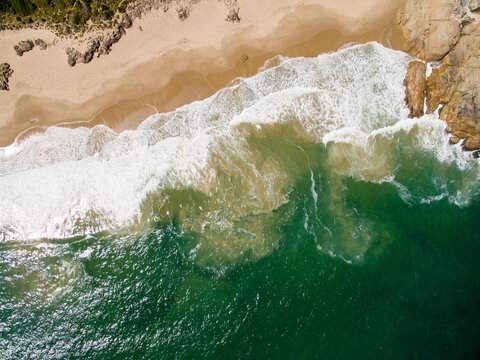 aerial of surf on sandy beach