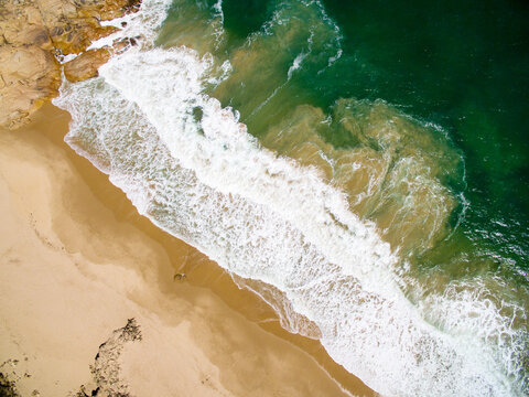 aerial of surf on sandy beach