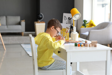 Cute little boy painting at home