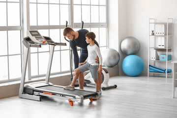 Physiotherapist working with boy in rehabilitation center