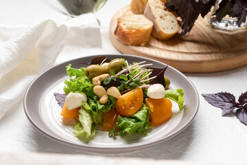 Plate with tasty fresh salad on light background, closeup