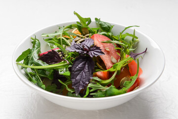 Bowl with tasty fresh salad on light background