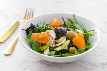 Bowl with tasty fresh salad on light background, closeup