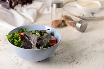 Bowl with tasty fresh salad and spices on light background, closeup