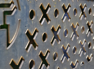 Plexiglass plate with cut noughts and crosses