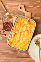Casserole with mashed potatoes and spices on wooden background