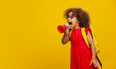 Little cute Black girl in red dress holding in hand and speaking in electronic gray megaphone