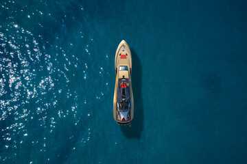 Super yacht on blue water top view. A huge super Mega yacht of gold color on blue water in Italy. Golden yacht open sea aerial view.