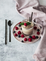 Affogato decorated with raspberries, blueberries and mint on a light background