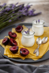 Lavender yogurt and red plums on a plate