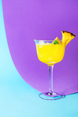 Glass of pineapple daiquiri cocktail on color background
