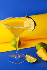 Glass of pineapple daiquiri cocktail on color background
