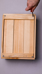 brown wooden box on a white background with a red phillips screwdriver background texture.the screwdriver is lying on a wooden box. the twisted screw is handmade. the box is handmade. wooden box with