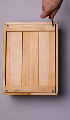 brown wooden box on a white background with a red phillips screwdriver background texture.the screwdriver is lying on a wooden box. the twisted screw is handmade. the box is handmade. wooden box with