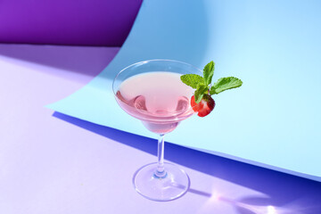 Glass of tasty cosmopolitan cocktail on color background