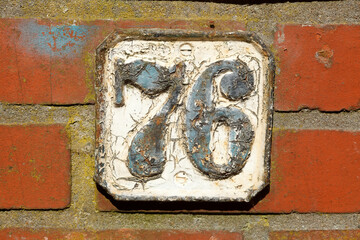 Altes Hausnummernschild Nummer Sechsundsiebzig, Backsteinmauer, Deutschland