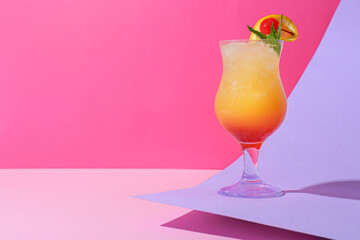 Glass of tasty summer cocktail on color background