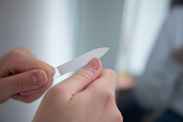 nail care. the girl sharpens her nails with a nail file. a broken nail. girl takes care of manicure manicure nail file thumb broken nail