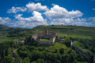 Fototapeta na wymiar Aerial panorama of Italy castles. The famous medieval castle on the hill. Italian historic castles. Soave castle aerial view, province of Verona, Italy.
