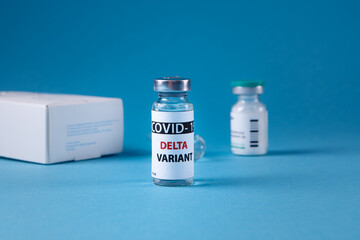Vaccine bottles covid - 19 delta variant, vials medicine and syringe injection isolated on blue. Coronavirus DELTA 2019-ncov.