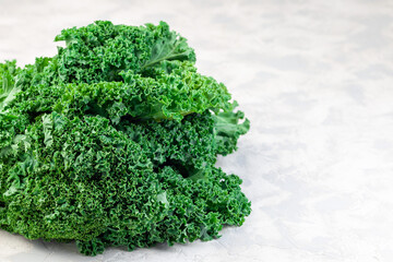 Curly kale leaves on gray background, horizontal, copy space