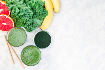 Green smoothie detox drink with kale, chlorella, banana and grapefruit, horizontal, top view copy...