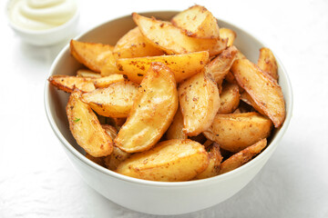 Bowl with tasty baked potato on light background