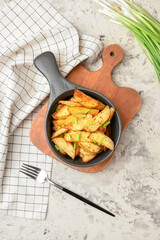 Baking dish with tasty potato on color background