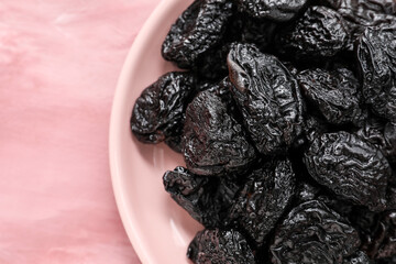 Plate with tasty prunes on color background, closeup