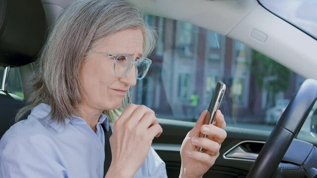 Upset middle aged woman receiving bad news on smartphone, car loan waiver