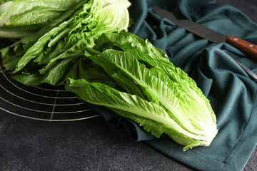 Grid with fresh romaine lettuce on dark background, closeup